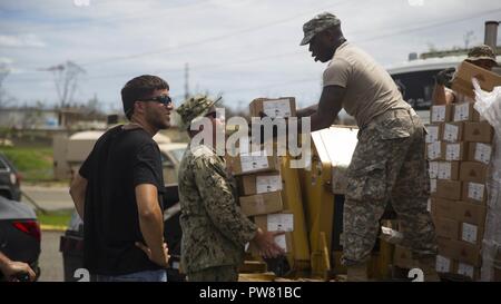 Stati Uniti Navy Petty Officer di prima classe David Fahy con anfibio battaglione di costruzione 2, e un'U.S. Soldato dell'esercito con la 101st combattere la Brigata Aerea, 101st Airborne Division, lavorano insieme per lo scarico di pallet di soccorso ad un centro di distribuzione in Ceiba, Puerto Rico, Ottobre 2, 2017. Il ventiseiesimo MEU è il supporto di Federal Emergency Management Agency, il piombo agenzia federale, per aiutare le persone colpite dall'uragano Maria per ridurre al minimo la sofferenza ed è un componente del complessivo intero-di-risposta del governo sforzo. Foto Stock