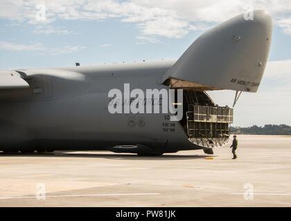 Un equipaggio membro da Dover Air Force Base, Del. orologi come un cargo bay porta si chiude su un C-5M Super galassia a Dobbins Air Base di riserva, Ga. Ottobre 2, 2017. Il piano poi partì per portare vitale di apparecchiature di comunicazione a Puerto Rico, che è stato catturato nel percorso distruttivo dell uragano Maria. Foto Stock