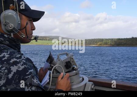 FASLANE in Scozia (sett. 29, 2017) Il personale specialista di 2a classe di Candelario Contreras, da Cedar Park, Texas, sorge guarda a bordo del Arleigh Burke-class guidato-missile destroyer USS Donald Cook (DDG 75) come la nave arriva a Faslane in Scozia, per una porta programmata visita sett. 29, 2017. Donald Cook, distribuita a Rota, Spagna, è sulla sua sesta patrol NEGLI STATI UNITI Sesta flotta area di operazioni a sostegno degli enti regionali alleati e partner, e degli Stati Uniti gli interessi di sicurezza nazionali in Europa. Foto Stock