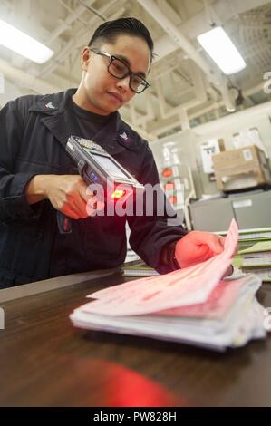5TH FLOTTA AREA DI OPERAZIONI (ott. 2, 2017) specialista della logistica 2a classe Yza Evangelista, una San Diego native, assegnati al reparto di alimentazione a bordo dell'assalto anfibio nave USS America (LHA 6), scansioni ricevute di trasformazione in questione principale camera. L'America è l'ammiraglia per l'America anfibio gruppo pronto e, con l'avviato xv Marine Expeditionary Unit, è distribuito negli Stati Uniti Quinta Flotta area di operazioni a sostegno della sicurezza marittima operazioni per rassicurare gli alleati e partner e preservare la libertà di navigazione e il libero flusso di commercio nella regione. Foto Stock