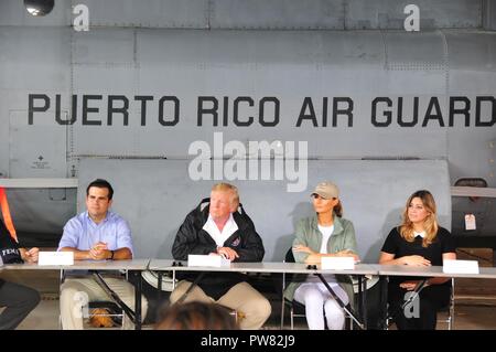 Gov. Ricardo Rossello, Pres. Donald Trump, First Lady Melania Trump e la moglie del governatore Beatriz Areizag Rosello si incontrano a Luis Muniz Air National Guard Base, home al Puerto Rico Guardia nazionale, per ascoltare locali e federali leader discutono i danni dell'uragano e gli sforzi di recupero. Foto Stock