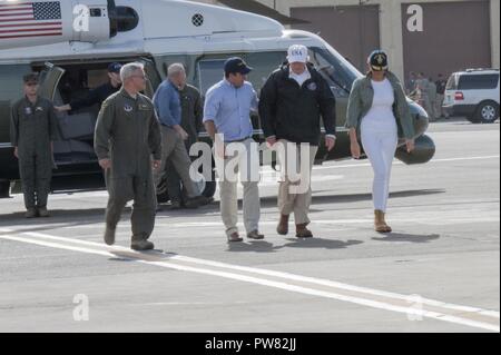 Stati Uniti Presidente Donald Trump e la First Lady Melania Trump sono accolti da Gov. Ricardo Rosello (centro) e U.S. Air Force Col. Raymond Figueroa, Commander, 156Airlift Wing dopo il loro ritorno a Muñiz Air National Guard Base, Ottobre 3, 2017, a seguito di un tour della devastazione dell'isola e della distribuzione degli aiuti ai residenti locali. Trump visitato Puerto Rico in seguito all'uragano Maria e si è incontrata con i responsabili locali in materia di tempesta agli sforzi di risposta. Foto Stock