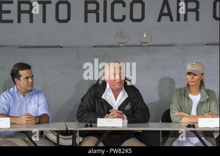 Puerto Rico Gov. Ricardo Roselló, U.S. Presidente Donald Trump e la First Lady Melania Trump discutere gli sforzi di rilievo nel corso di una riunione del gabinetto a Muñiz Air National Guard Base, Carolina, Puerto Rico, Ottobre 3, 2017. Il Presidente ha visitato Puerto Rico in seguito all'uragano Maria e si è incontrata con i responsabili locali in materia di tempesta agli sforzi di risposta. Foto Stock