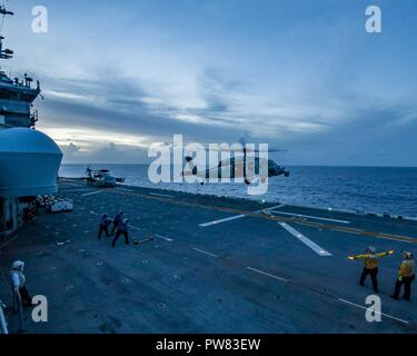 Mar dei Caraibi (ott. 03, 2017) segnale di marinai l'atterraggio di un MH-60S Sea Hawk elicottero come l'assalto anfibio nave USS Wasp (LHD 1) transita il Mar dei Caraibi a sostegno dei soccorsi in Puerto Rico. Vespa è assistere con i soccorsi dopo il passaggio dell uragano Maria. Il Dipartimento della difesa è di sostenere la Federal Emergency Management Agency, il piombo agenzia federale, per aiutare le persone colpite dall'uragano Maria per ridurre al minimo la sofferenza ed è un componente del complessivo intero-di-risposta del governo sforzo. Foto Stock