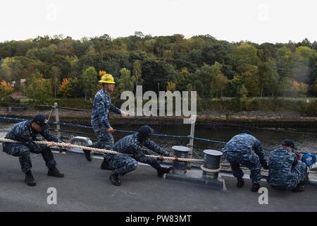 FASLANE in Scozia (sett. 29, 2017) marinai heave line a bordo della Arleigh Burke-class guidato-missile destroyer USS Donald Cook (DDG 75) come la nave arriva a Faslane in Scozia, per una visita di porta. Donald Cook è distribuita a Rota, Spagna, sulla sua sesta patrol NEGLI STATI UNITI Sesta flotta area di operazioni a sostegno degli enti regionali alleati e partner, e degli Stati Uniti gli interessi di sicurezza nazionali in Europa. Foto Stock