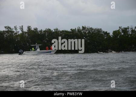 Coast Guard i membri e i funzionari con il Miami polizia Pattuglia Marina valutare le navi spostato dall uragano Irma nell'area di cena il tasto vicino a Miami, Ottobre 4, 2017. I barcaioli sono esortati ad esercitare estrema cautela nei porti e vie navigabili colpiti dall uragano Irma, come rischi durante la navigazione sono stati creati dalla tempesta. Foto Stock