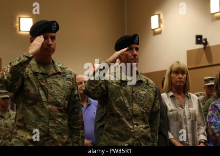 Brig. Gen. Stephen Smith, Vice Comandante generale della prima divisione di fanteria e il Mag. Gen. Giuseppe Martin, comandante generale, 1INF. Div. e Fort Riley, salutate bandiera durante l inno nazionale a una vittoria con onori cerimonia di premiazione che si terrà presso la prima divisione di fanteria quartier generale, 3 ottobre 2017, sulla Fort Riley, Kansas. La cerimonia si è svolta ad accogliere Smith e la sua famiglia a Fort Riley e la pietra focaia colline regione. Foto Stock