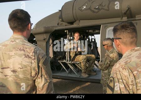Sgt. Jake Briley, un capo equipaggio assegnati al 2° Battaglione, 149a di supporto generale reggimento di aviazione, dimostra il funzionamento delle cinture di sicurezza anteriori all'interno del UH-60 Blackhawk elicottero prima di facilitare a caldo e a freddo per la formazione di carico con i soldati del secondo battaglione, 7° reggimento di cavalleria 'fantasma', 3° Brigata corazzate contro la squadra, 1° Divisione di cavalleria a Camp Buehring, Kuwait, Ott 4 come parte della parete del deserto. Le unità praticato il montaggio e lo smontaggio di un UH-60 Blackhawk al fine di condurre le operazioni di combattimento. Parete del deserto è stata una partnership evento di formazione progettati per realizzare l'interoperabilità Foto Stock