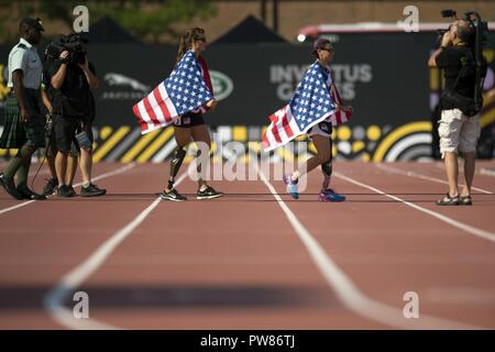 Bandierine americane drappeggio U.S. Air Force Captain Christy saggia e U.S. Marine Corps veterano Sarah timone come entrano in una premiazione per il 2017 Invictus Games a Toronto in Canada da settembre 24, 2017. La Invictus Giochi, istituito dal principe Harry nel 2014, riunisce i feriti e i veterani feriti da 17 nazioni per 12 adaptive eventi sportivi, tra cui via e un campo basket in carrozzella, Rugby in carrozzina, nuoto, seduta a pallavolo e nuovo per il 2017 giochi, golf. Foto Stock