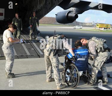 Cittadino di riserva aviatori assegnati per il quarantacinquesimo di medicina aeronautica squadrone di evacuazione, aiutare un paziente a bordo di una C-17 Globemaster III in St. Croix, U.S. Isole Vergini, Sett. 24, 2017. Cittadino di riserva aviatori condotta missione umanitaria di St. Croix per evacuare le vittime colpite dall'uragano Maria. Foto Stock