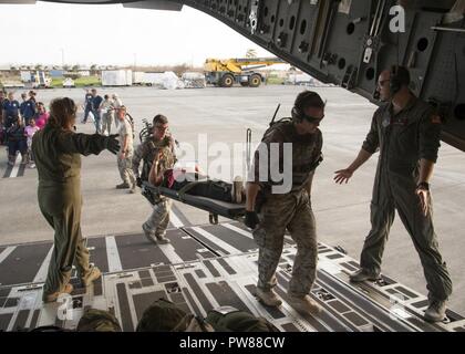 Cittadino di riserva aviatori assegnati per il quarantacinquesimo di medicina aeronautica squadrone di evacuazione, portano i pazienti a bordo di una C-17 Globemaster III in St. Croix, U.S. Isole Vergini, Sett. 24, 2017. Cittadino di riserva aviatori condotta missione umanitaria di St. Croix per evacuare le vittime colpite dall'uragano Maria. Foto Stock