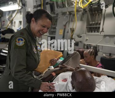 Stati Uniti Air Force Il Mag. Gavril Goodman assegnati per il quarantacinquesimo di medicina aeronautica squadrone di evacuazione, comfort di un paziente a bordo di una C-17 Globemaster III mentre lungo il tragitto da St. Croix di Dobbins Air Base di riserva, Ga., Sett. 24, 2017. Cittadino di riserva aviatori condotte missioni umanitarie di St. Croix per evacuare le vittime colpite dall'uragano Maria. Foto Stock