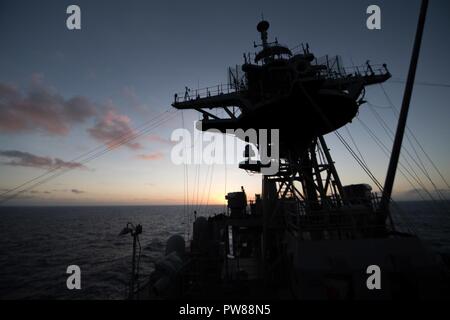 Oceano Pacifico (GEN. 14, 2018) il sole tramonta come il dock anfibio sbarco nave USS Pearl Harbor (LSD 52) cuoce a vapore nel Pacifico. Pearl Harbor, parte dell'America anfibio gruppo pronto, con l'avviato xv Marine Expeditionary Unit (MEU), è operativo in Indo-Asia-regione del Pacifico per rafforzare i partenariati e servire come una pronta risposta in vigore per qualsiasi tipo di emergenza. Foto Stock