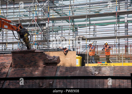 3 operai guardare la demolizione del muro di mattoni a nuova barriera Foss stazione di pompaggio (aggiornamento a Città del diluvio difesa) - York, North Yorkshire, Inghilterra, Regno Unito. Foto Stock