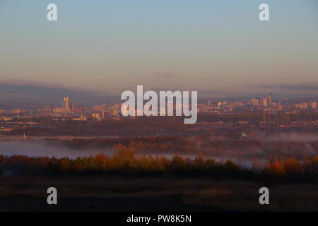 Leeds City skyline durante una nebbiosa mattina sunrise Foto Stock