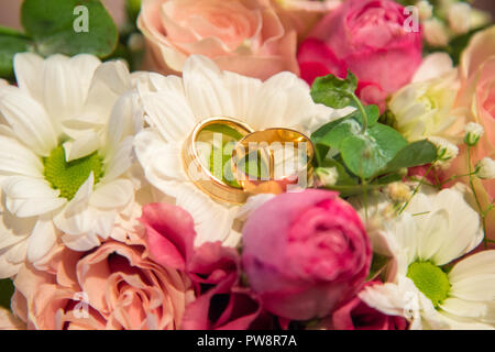 Gli anelli di nozze sul bellissimo panorama naturale bouquet di fiori Foto Stock