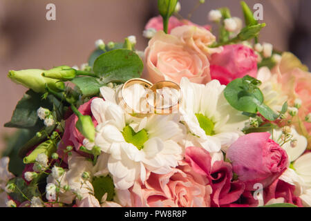Gli anelli di nozze sul bellissimo panorama naturale bouquet di fiori Foto Stock