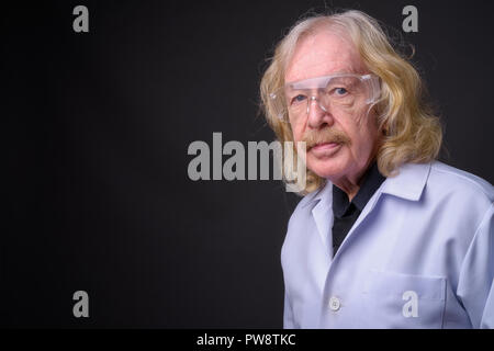 Senior medico uomo con i baffi indossando occhiali protettivi di nuovo Foto Stock