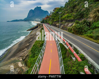 Autostrada del mare. Splendida strada e pista ciclabile. Bicicletta e via strada e accanto al mare blu nella città di Rio de Janeiro. Tim Maia pista ciclabile. Foto Stock