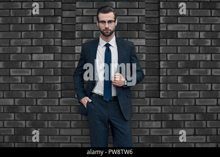 Un fiducioso vista del leader. Un giovane imprenditore in bicchieri e con una barba guarda direttamente a voi Foto Stock