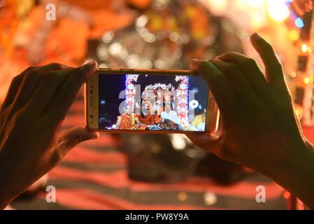 Di Allahabad, Uttar Pradesh, India. Xiii oct, 2018. Un devoto clicca le foto sul suo cellulare durante una processione religiosa per contrassegnare il festival di Dussehra in Allahabad, India, Venerdì 13 ottobre, 2018. Il festival annuale che commemora la 10-armati dea Durga il massacro di un demone re, celebrando la vittoria del bene sul male. Kali e Durga sono forme della suprema dea Indù Devi. Credito: Prabhat Kumar Verma/ZUMA filo/Alamy Live News Foto Stock