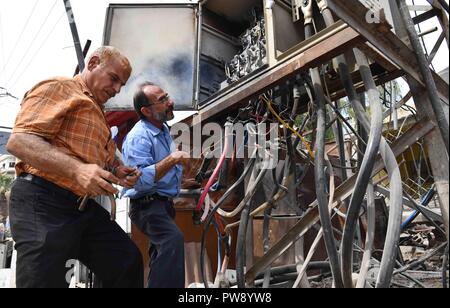 (181013) -- Damasco, ottobre 13, 2018 (Xinhua) -- Foto scattata il 8 ottobre, 2018 mostra gli elettricisti che fissa le linee di alimentazione nella città di Kafr Batna nell'orientale Ghouta campagna di Damasco, Siria. Persone in Kafr Batna e altre aree di Ghouta orientale era rimasta per anni senza elettricità fino a quando l'esercito siriano liberata la regione da ribelli lo scorso maggio. Il governo siriano ha iniziato ad esercitare sforzi per il risanamento delle zone. Ora il 70 per cento dell'elettricità è stata indietro per le aree popolate nell est Ghouta, secondo un'emergenza elettrica ufficiale del Dipartimento. (Xinhua/Ammar Safarj Foto Stock