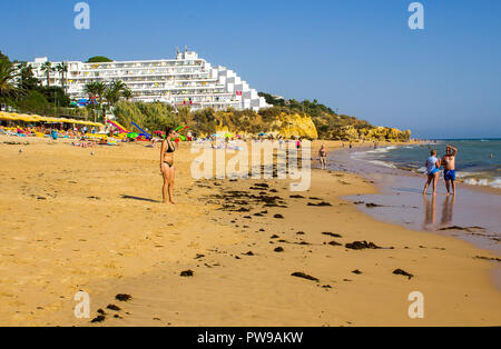 28 settembre 2018 una vista lungo Oura Praia spiaggia di Albuferia Portogallo su Algarve con le sue scogliere lettini per prendere il sole e sabbia Foto Stock