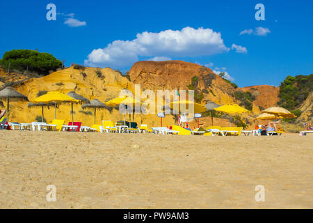 28 settembre 2018 una vista lungo Oura Praia spiaggia di Albuferia Portogallo su Algarve con le sue scogliere lettini per prendere il sole e sabbia Foto Stock