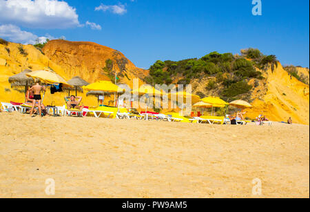 28 settembre 2018 una vista lungo Oura Praia spiaggia di Albuferia Portogallo su Algarve con le sue scogliere lettini per prendere il sole e sabbia Foto Stock