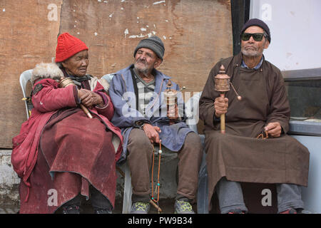 Vecchia donna Ladakhi e gli uomini la filatura ruote della preghiera, Leh, Ladakh, India Foto Stock