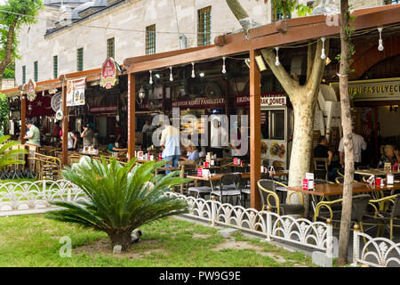 Una fila di piccoli ristoranti sotto una tettoia in legno con i commensali seduti ai tavoli fuori, Istanbul, Turchia Foto Stock