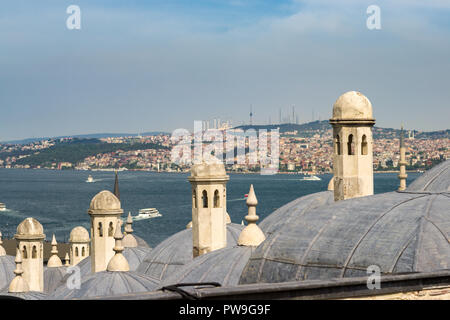 Camini in Pietra di edifici a cupola con il Bosforo e lato Asiatico di Istanbul in background, Turchia Foto Stock