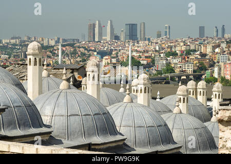 Camini in Pietra di edifici a cupola con Golden Horn Metro ponte in background, Istanbul, Turchia Foto Stock