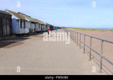 Sandilands, Lincolnshire, Regno Unito. Ottobre 07, 2018. Vacanzieri godere di una lunga linea di varie dimensioni cabine sulla spiaggia, sul lungomare a Sandilands vicino a su Foto Stock