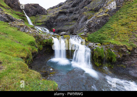 Fotografo presso una piccola cascata appena fuori la città di Grundarfjörður sulla penisola Snaefellsnes, Islanda Foto Stock