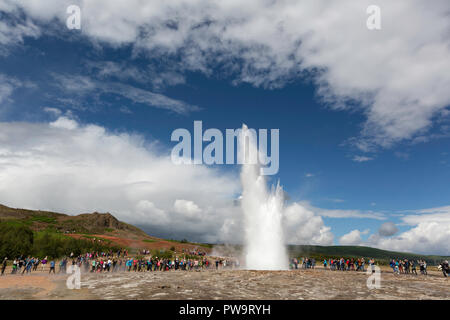 I turisti si riuniscono per guardare Strokker geyser, 'geysir', un eruzione a molla Haukadalur, Islanda Foto Stock