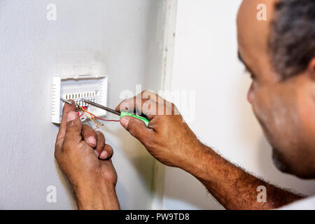 Miami Beach Florida, aria condizionata, meccanico, lavoratore, lavoratori, riparatori, termostato digitale, installazione, installazione, riparazione, filo, attrezzo, Latino ispanico latino Foto Stock