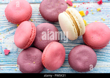 Dolce macarons su uno sfondo blu. Torte alla moda. Foto Stock