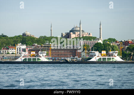 Veicolo ferries ormeggiata al porto di Eminonu con il Museo Hagia Sophia in background, Istanbul, Turchia Foto Stock