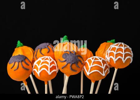 Concetto di festa di Halloween con torta vetrato appare su sfondo nero Foto Stock
