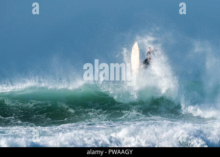 Un surfista in sella a una grande onda a Fistral a Newquay in Cornovaglia. Foto Stock