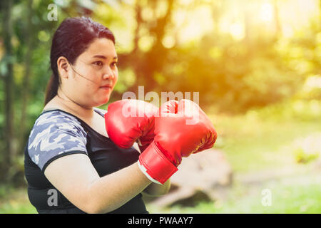 Lotta contro il concetto di grasso. Ragazza donna grassa boxe fighter con perdere peso Foto Stock