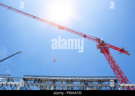 Il grande alto paranco della gru edilizia industriale con cielo blu sullo sfondo Foto Stock