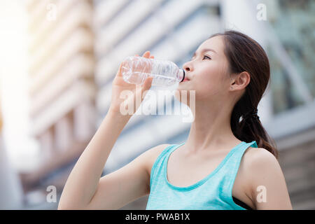 Sport sano carino asian teen acqua potabile sullo sfondo della città Foto Stock