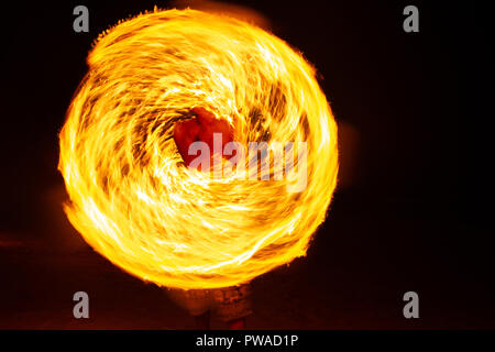 Fire ballerini Swing fire spettacolo di danza spettacolo di fuoco sulla spiaggia uomo danza giocoleria con il fuoco Foto Stock