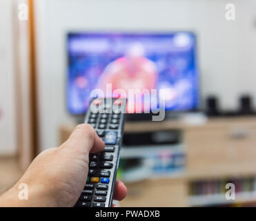 Uomo in possesso di un telecomando Foto Stock