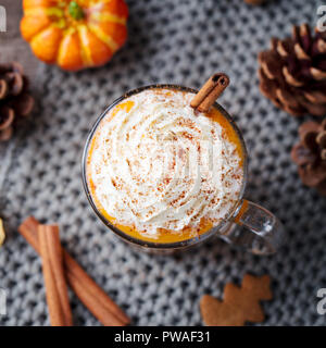 Latte macchiato di zucca con spezie e panna montata. Sfondo grigio. Close up. Vista superiore Foto Stock