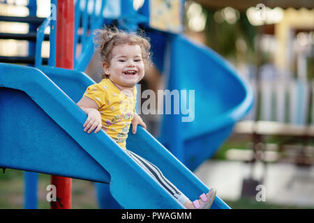 Piccolo bimbo giocare al parco giochi all'aperto in estate. Foto Stock