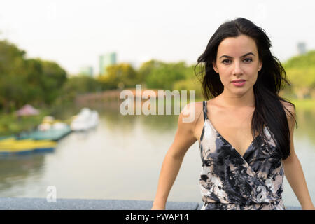 Giovane bella donna ispanica rilassante nel parco Foto Stock