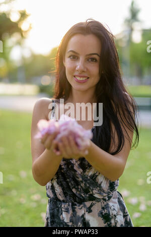 Giovane bella donna ispanica rilassante nel parco Foto Stock